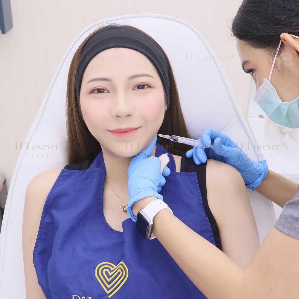 Woman receiving shoulder vaccination from masked healthcare worker in clinic
