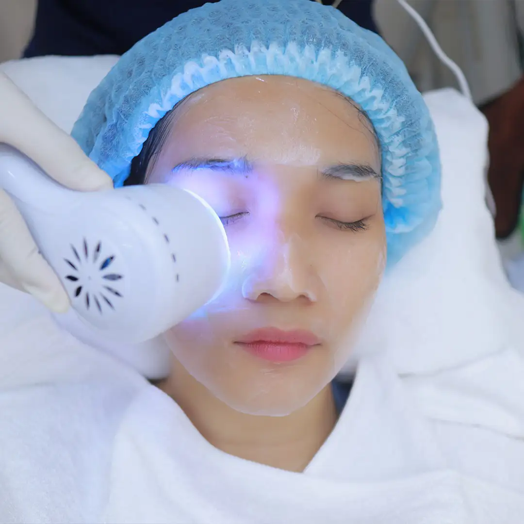 Hydrating blue light therapy facial on masked client in spa