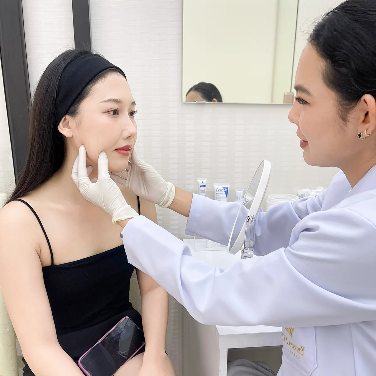 HIFU facial consultation: practitioner examines clients cheek in treatment room