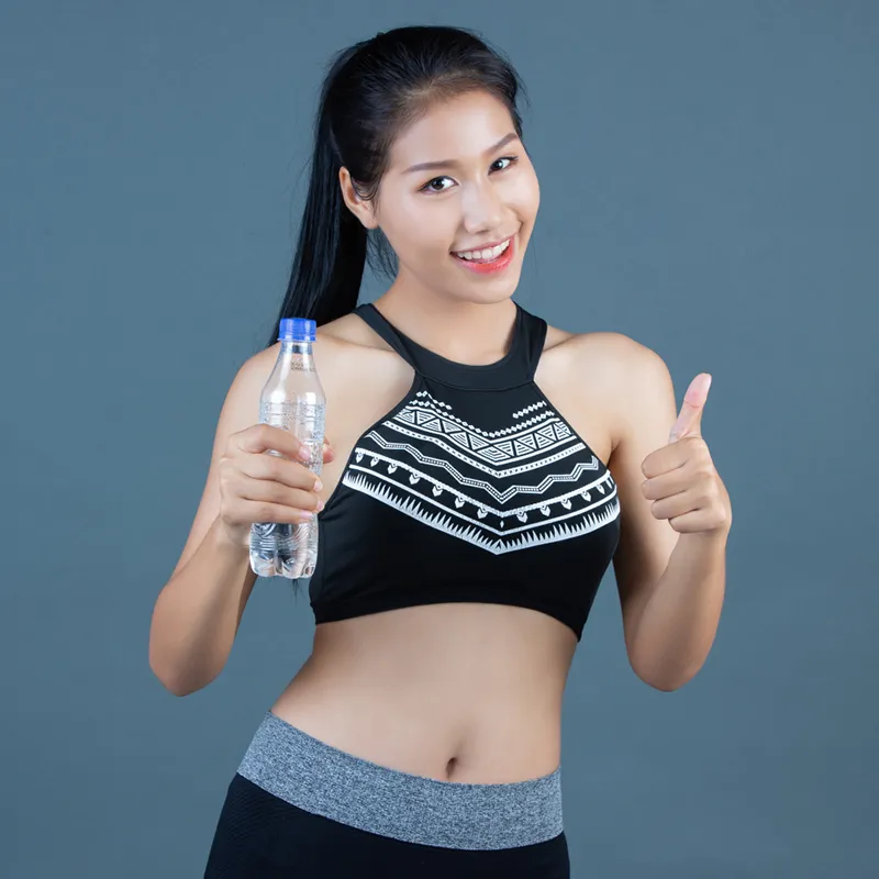 Fit woman holding water bottle, thumbs-up — hydration and fitness lifestyle