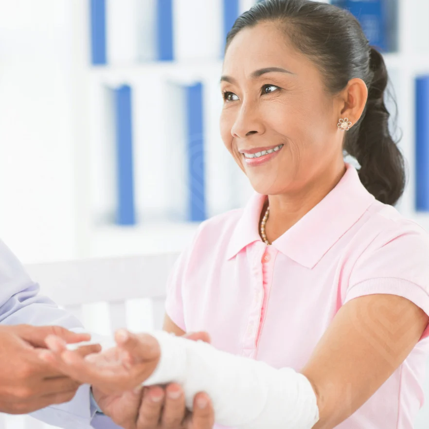 Patient with bandaged forearm receiving professional wound care consultation in clinic