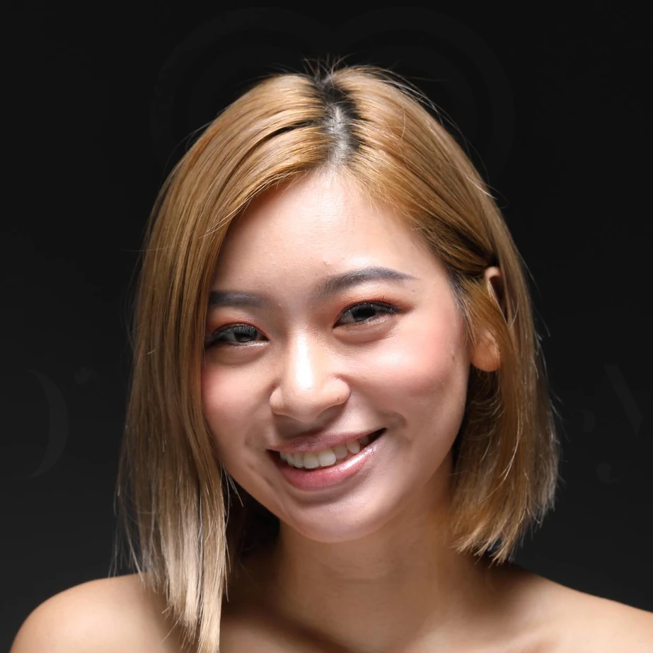 Smiling blonde woman portrait with chin-length bob, natural makeup, dark background