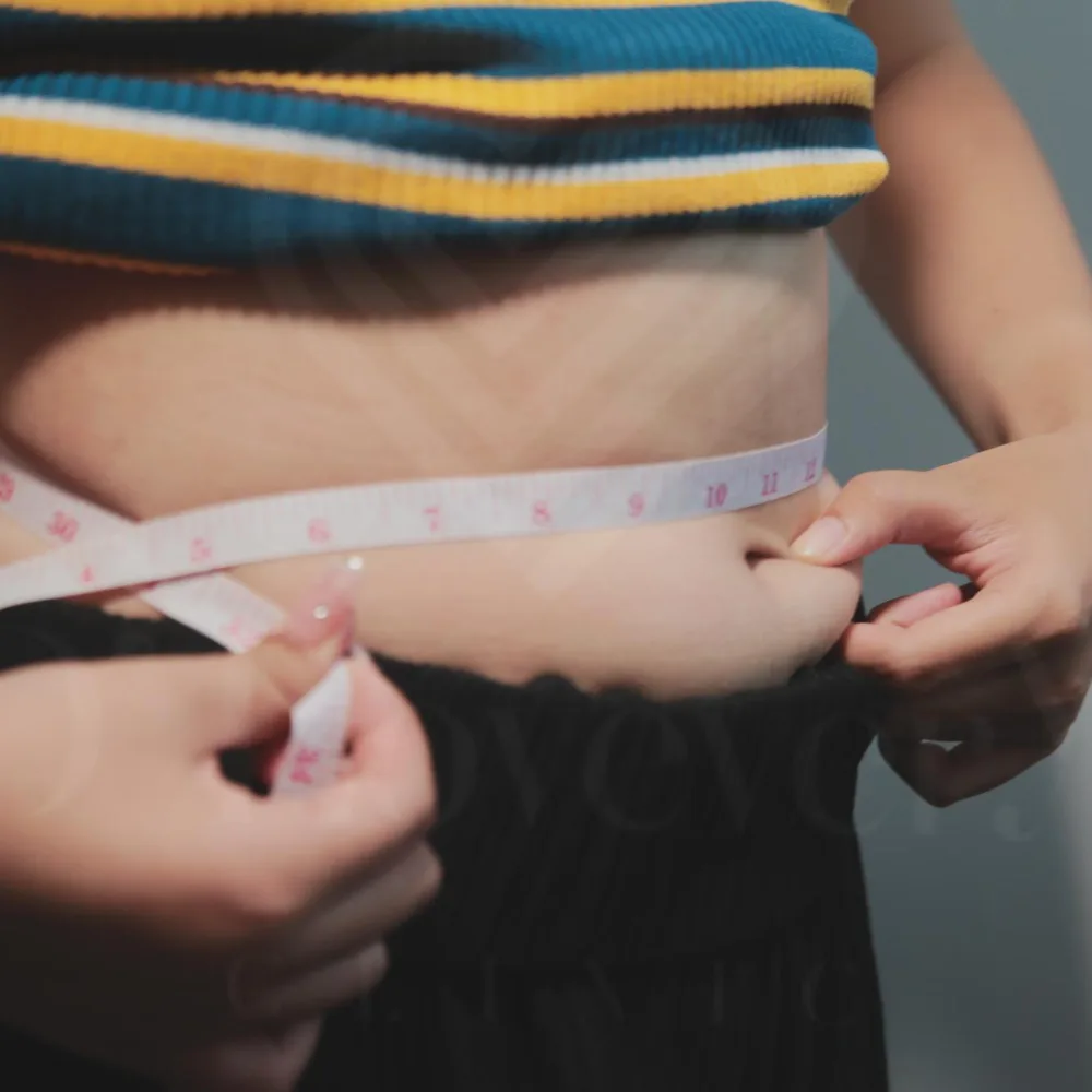 Waist measurement with tape measure held above the navel