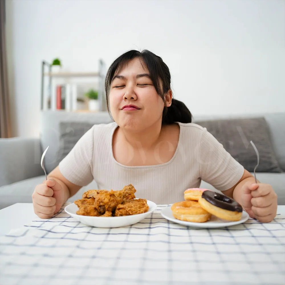 Person savoring fried chicken and glazed donuts at home