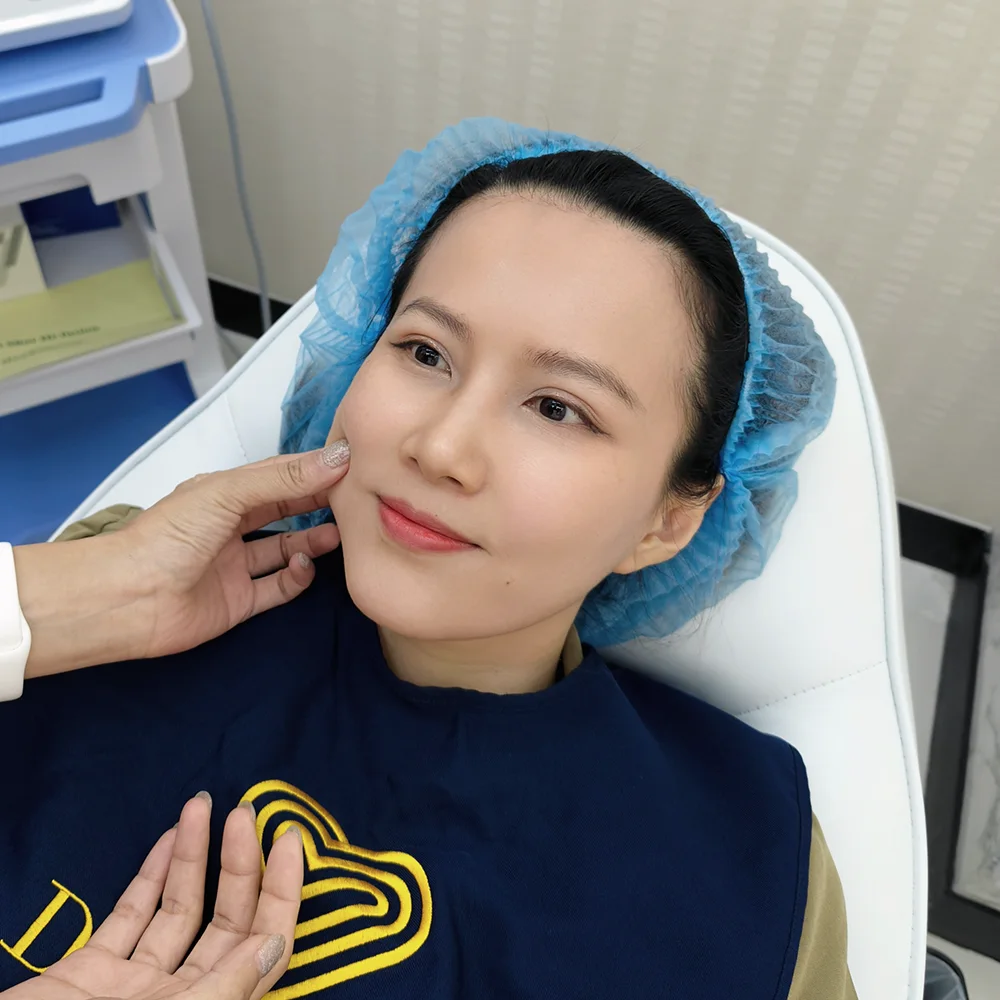 HIFU facial consultation: patient reclines as clinician gently examines cheek in aesthetic clinic