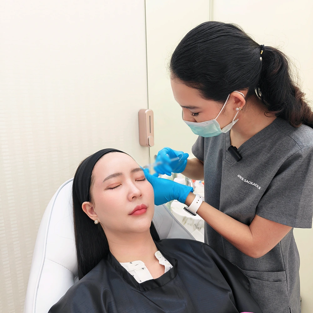 Temple filler injection performed on relaxed patient by clinician in cosmetic clinic.
