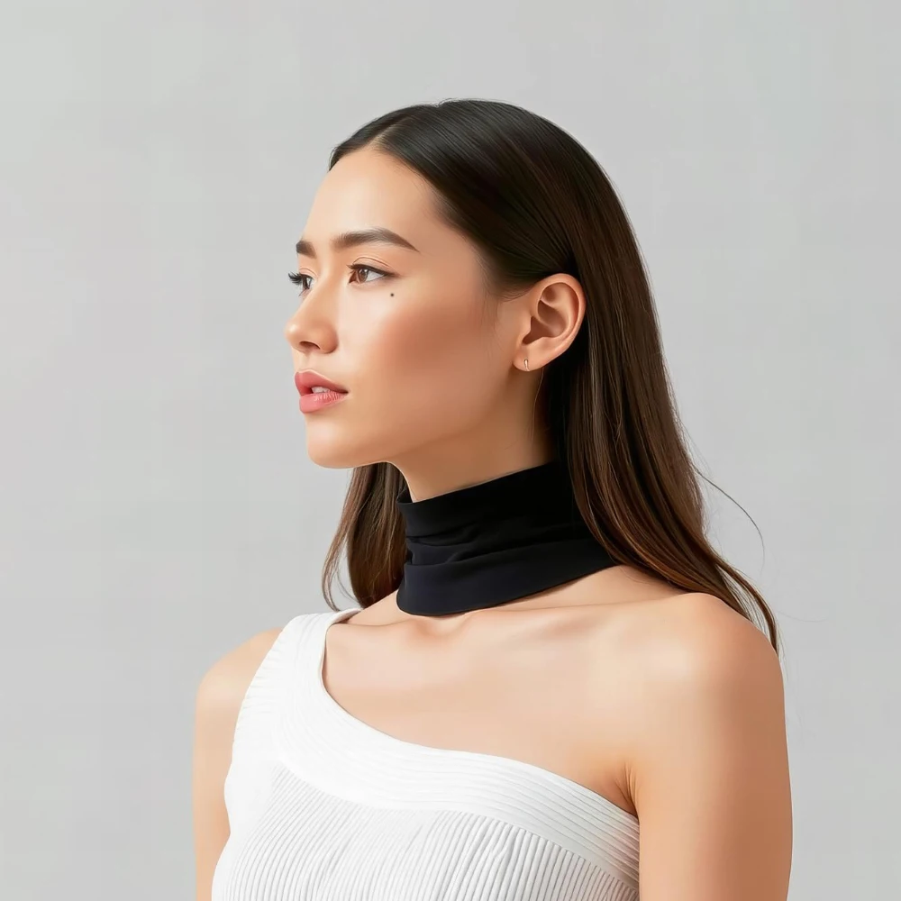 Elegant profile portrait: young person with under-eye beauty mark, white one-shoulder top, black neckband