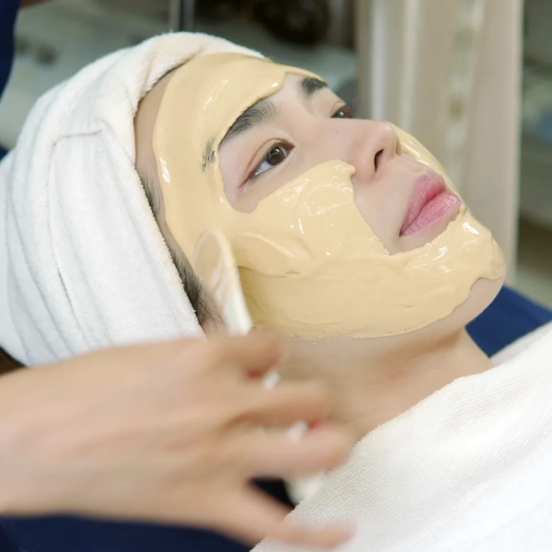 Professional spa facial mask treatment with spatula on relaxed client