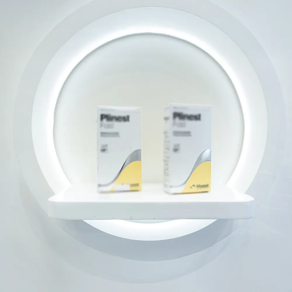 Minimalist backlit circular niche with two personal care packaging boxes on slim white shelf